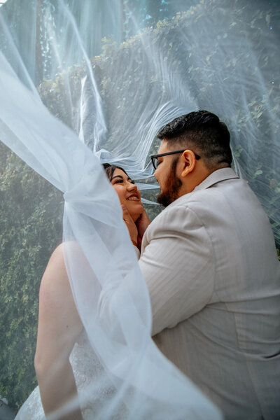 phoenix bride and groom cuddle under veil
