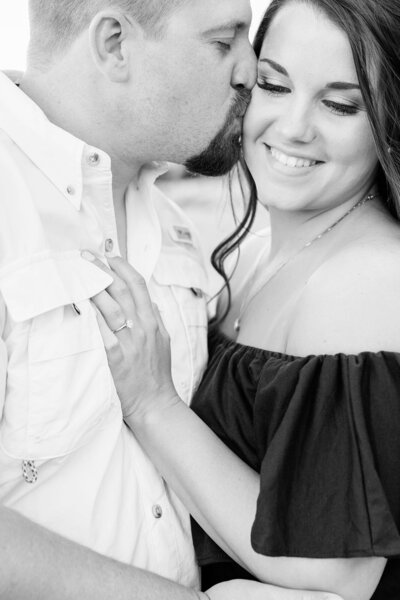 Engagement Portrait of couple kissing with engagement ring