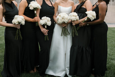bow wedding dress worn by beautiful bride at cocktail hour with bridal party in loews hotel in downtown kansas city missouri