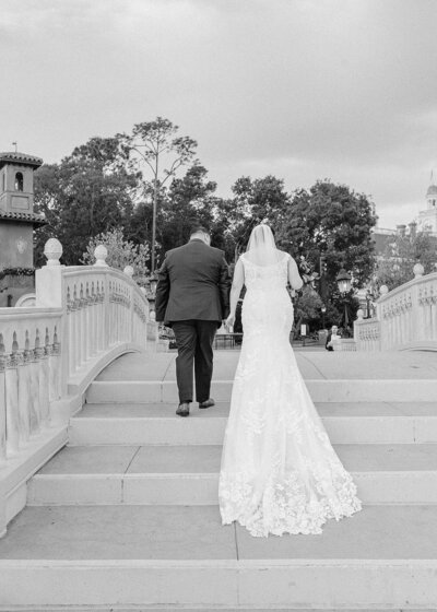 Black and white photo of bride and groom walking down the aisle at Disney's fairytale weddings in Italy Isola in Epcot