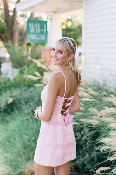 Malibu senior portrait of girl in pink dress looking back at camera