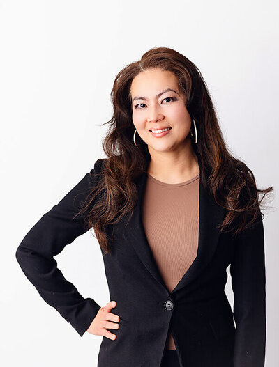 Woman poses with hand on hip during her studio session at Angela Marie Media.