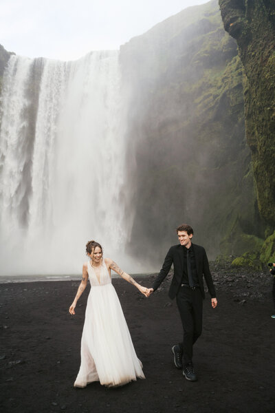 Bride and groom standing in front of an Oregon waterfall