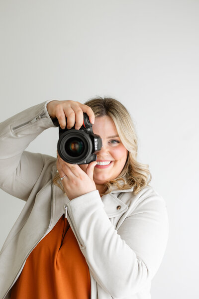 Branding photography session of a photographer with her camera out.