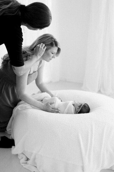 professional hair stylist fixes mom's hair at newborn session
