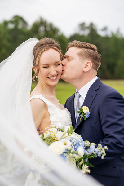 bride and groom laugh feeding each other cake at wedding at the Stockroom at 230 in Downtown Raleigh