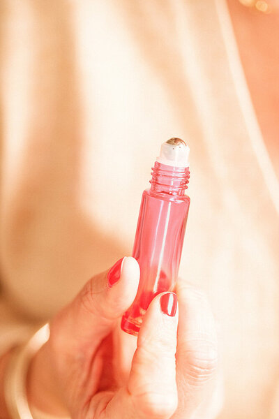 Main tenant un roll on rose de parfum personnalisé aux huiles essentielles.