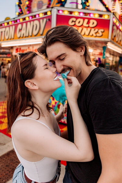 a couple sharing cotton candy at the calgary stampede