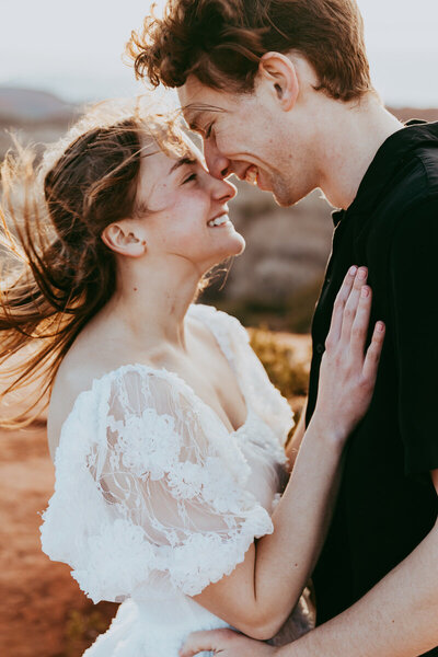 couple poses for an engagement photo as they smile