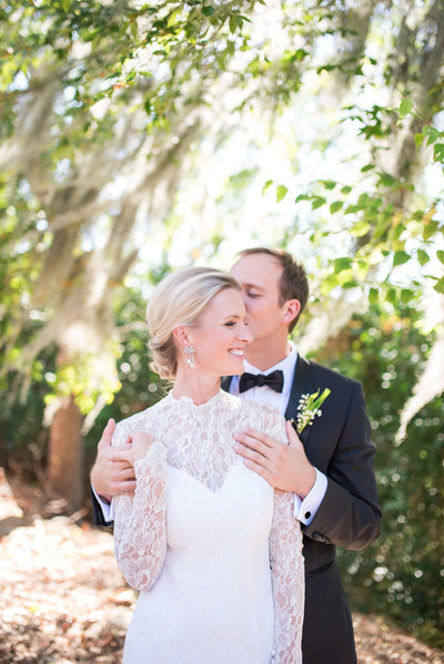 bride and groom kissing under spanish moss