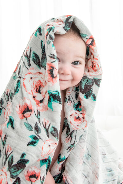 Baby wrapped in a floral blanket smiling