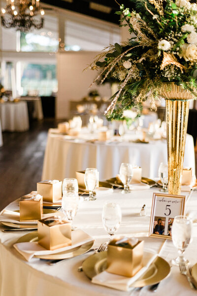 Image of a table with gold wedding favors and green centerpiece