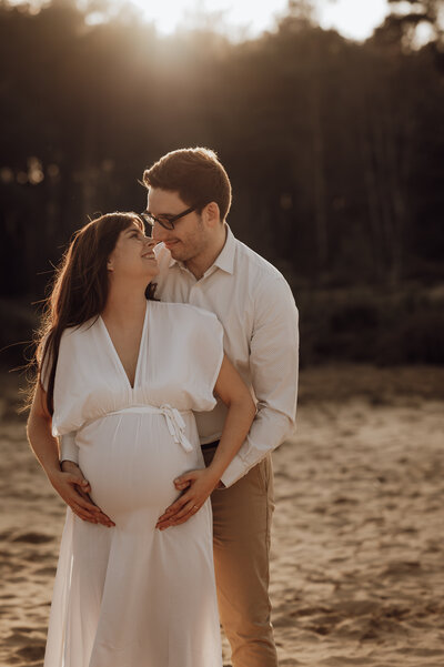 Koppel omhelst elkaar tijdens zwangerschapsshoot in Antwerpen