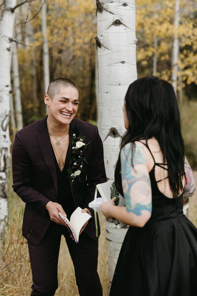 Two Brides laughing while exchanging vows surrounded by aspen trees in Vail Colorado