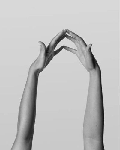 Two hands reaching toward each other in soft light, symbolizing connection, guidance, and support.