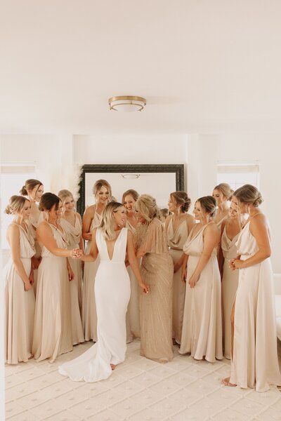Bride Getting Into Dress with Bridal Party & Mother of the Bride - Bre & Chris | Converted Basketball Court Wedding – Featured in Brides Magazine