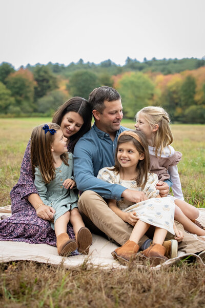 Family of five during lifestyle photo session with sun setting behind them