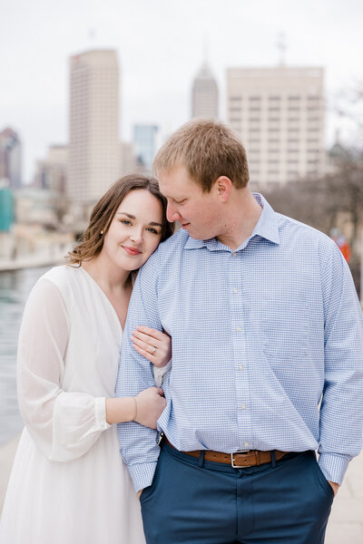 couple nuzzing together downtown Indianapolis photographed by Kaitlin Mendoza Photography, an Indianapolis engagement photographer