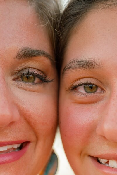mother and daughter side by side close up photo of their eyes 