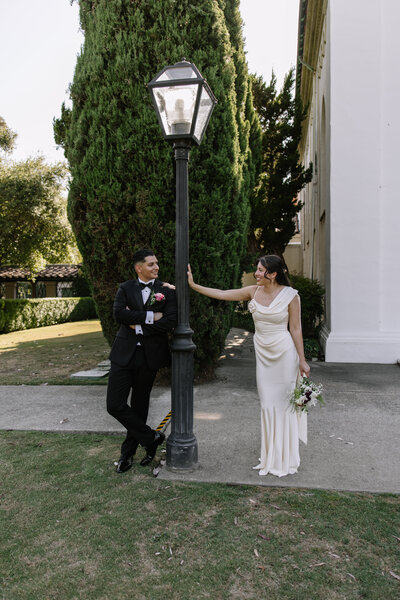 Katie and Sebastian leading on a light post during their elopement photos.