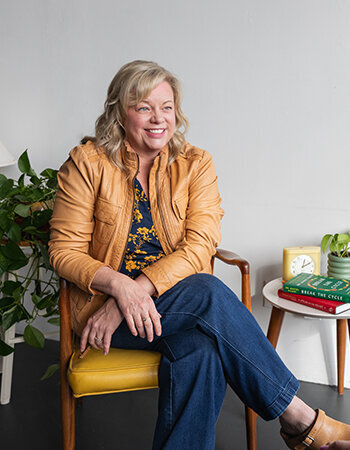 Lori Lubbers in a chair with her favorite books