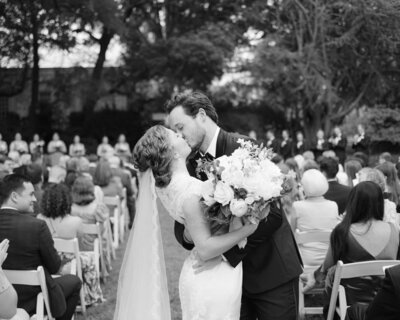 Couple celebrating their wedding and kissing in a dip style position.