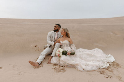 Bride and groom sharing a moment in the sand dunes during their Michigan wedding