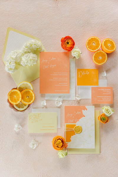 Bright citrus inspired wedding invitation suite flatlay with modern typography