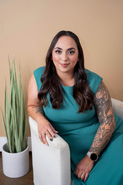 Stephanie, Founder of BCWise Consulting, sitting in a chair with a plant next to her 