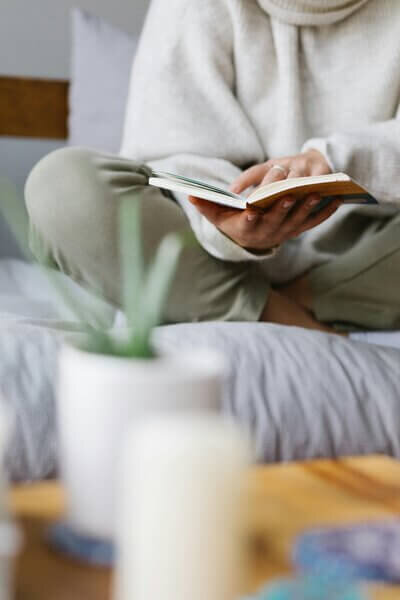Sarah sitting on bed with book copywriting services for small businesses