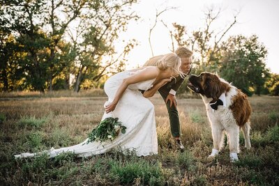 Bride and groom taking photo with dog at sunset at Designs by Sundown.
