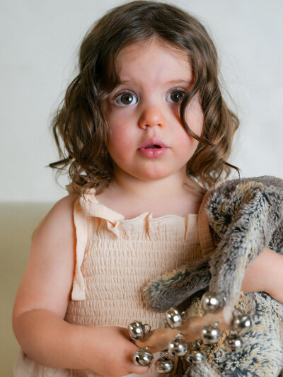 doe eyed expression on toddler girl while holding her lovey