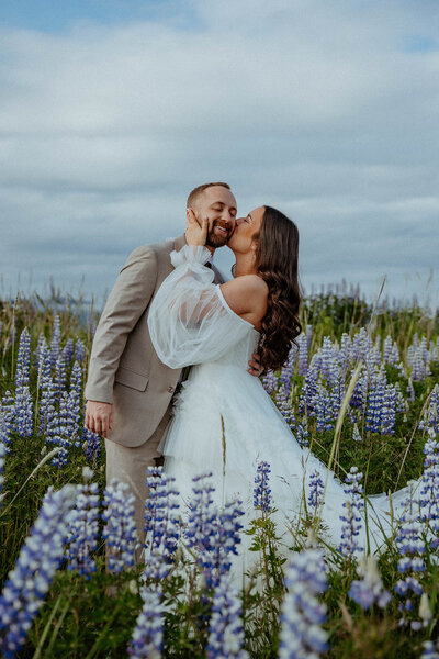 bride and groom kissing surrounded by flowers