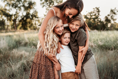 mom hugging her three children