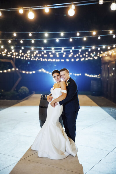 The Hamilton Manor | Bride and groom on patio under twinkle lights during wedding night photo | Hamilton Township, New Jersey