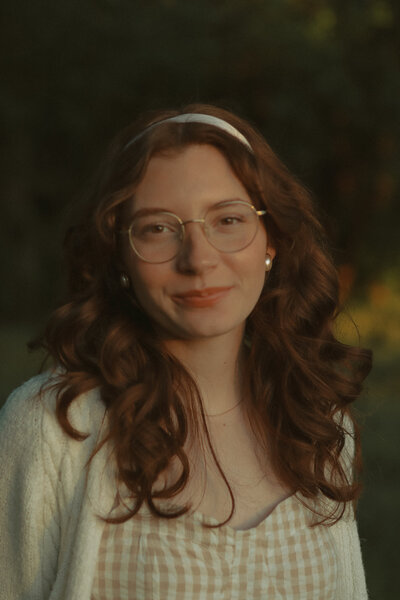 A woman can be seen smiling at the camera in a portrait style photo.