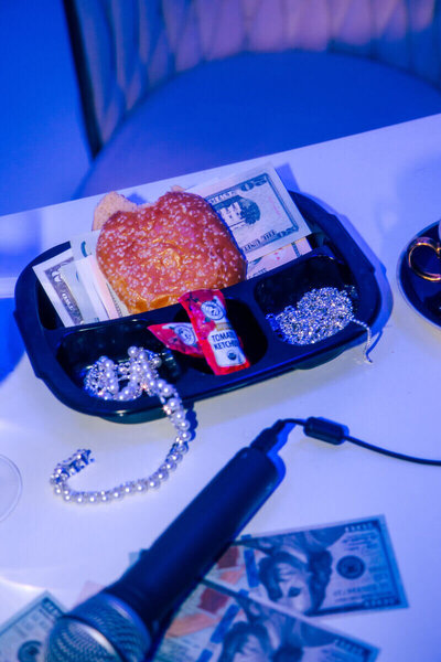 Desk with microphone and burger bun with cash