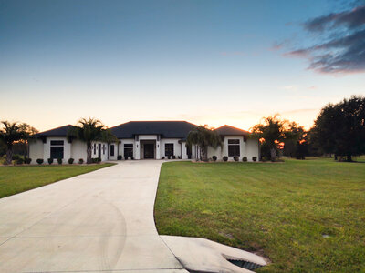 long driveway, metal roof, asphalt roof, white house black roof