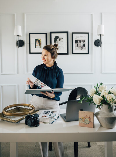 A woman hanging photo frames on a wall. Photographed by Casey McMurray Photographer