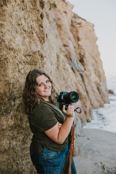 Kayla Marie, Midwest photographer, smiling with camera, dedicated to capturing candid and heartfelt moments.
