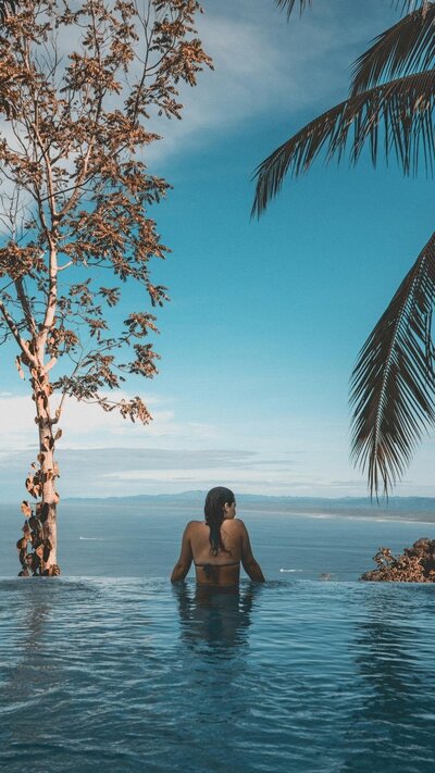 Woman in pool looking over edge