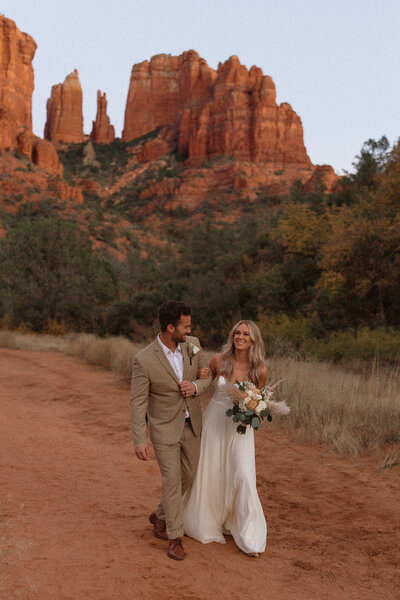 Romantic couples session with bride and groom standing together in a lake during golden hour