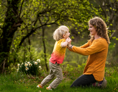 little boy jumps into mom's arms during a spring family photo session in White Sulphur Springs, NY