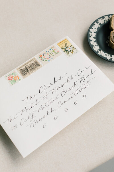 White envelope with black modern calligraphy and vintage postage for a Connecticut wedding.