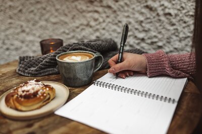 hand som håller penna och skriver i en kalender, miljö – café