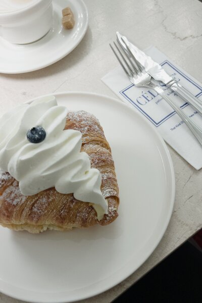 Pastry on a plate next to silverware on a table