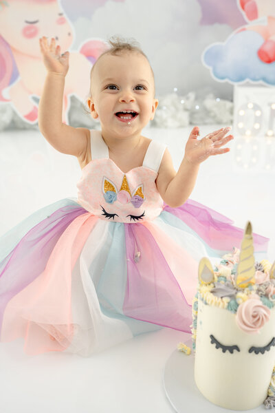 Girl in dress standing next to large ONE during a cake smash session— captured by Alliston and Barrie cake smash photographer.