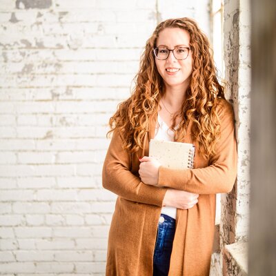 Headshot of designer holding a notebook