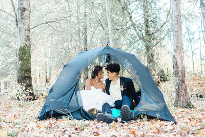 A couple sitting in a tent in the woods during their Ontario elopement