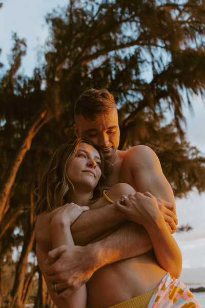 Man holding girl from behind and kissing her